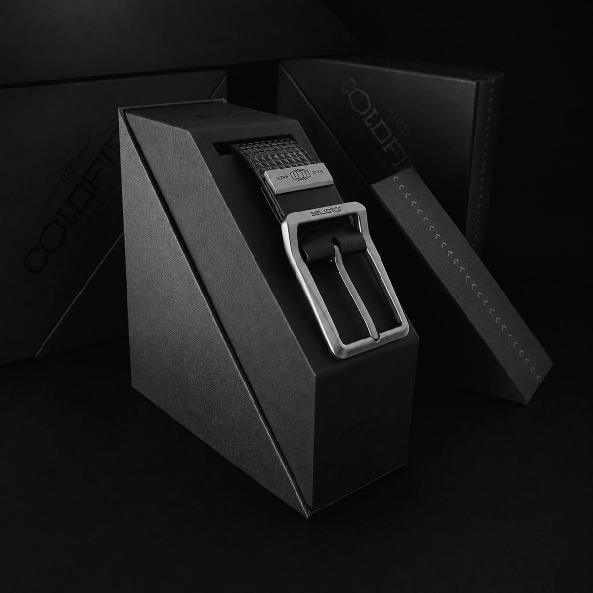 ColdFire Titan Grip black leather belt in presentation box — 
titanium DLC pin buckle, structured display cradle, 
matte black gift packaging